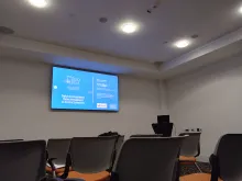 Ansicht der Präsentation auf dem ODRL Workshop mit Stühlen und Bildschirm