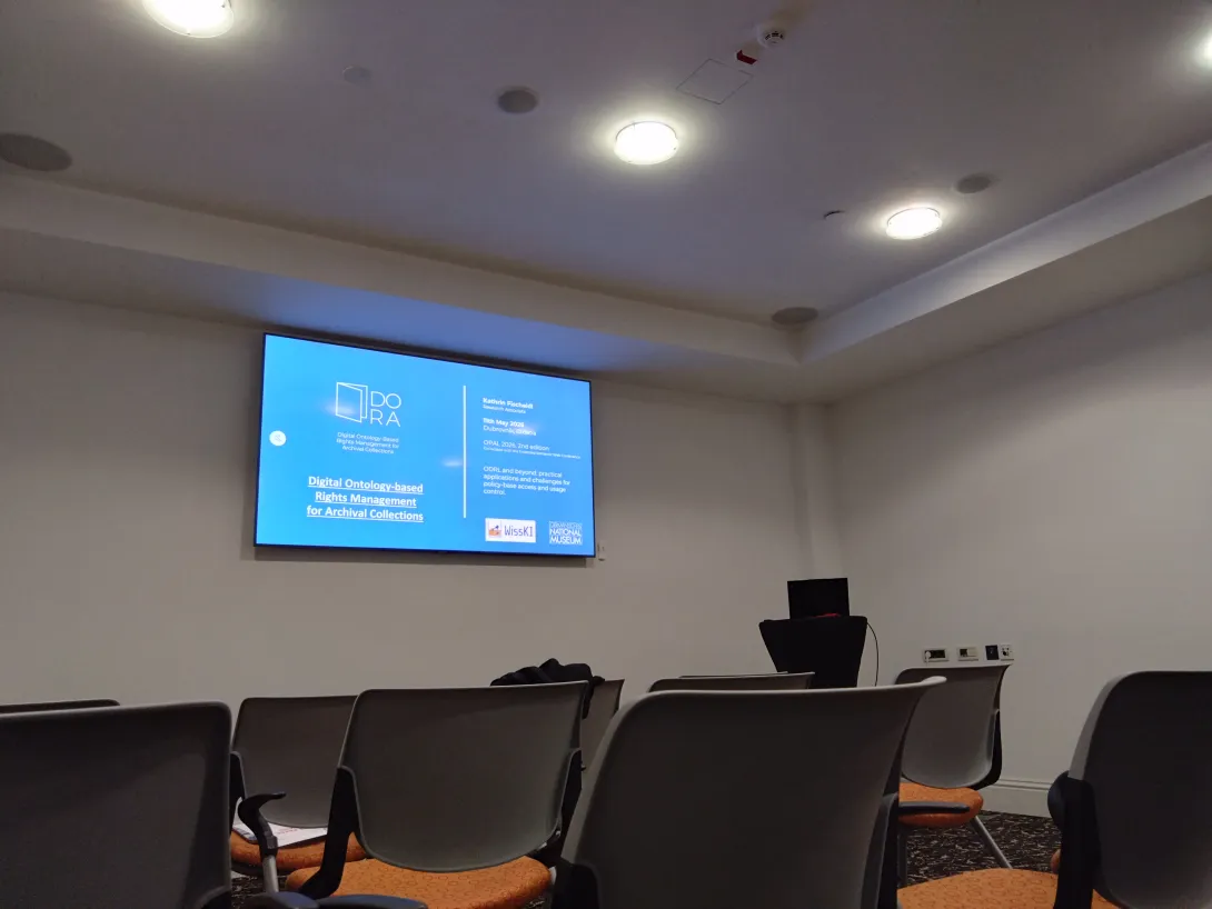 Ansicht der Präsentation auf dem ODRL Workshop mit Stühlen und Bildschirm